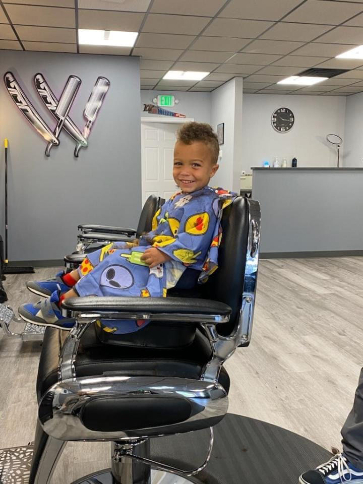 Happy young client after a fresh kids' cut at Work of Art Barbershop