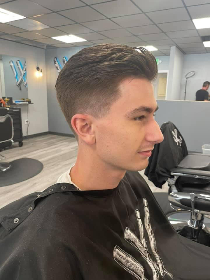 Slicked-back taper with longer top at Work of Art Barbershop